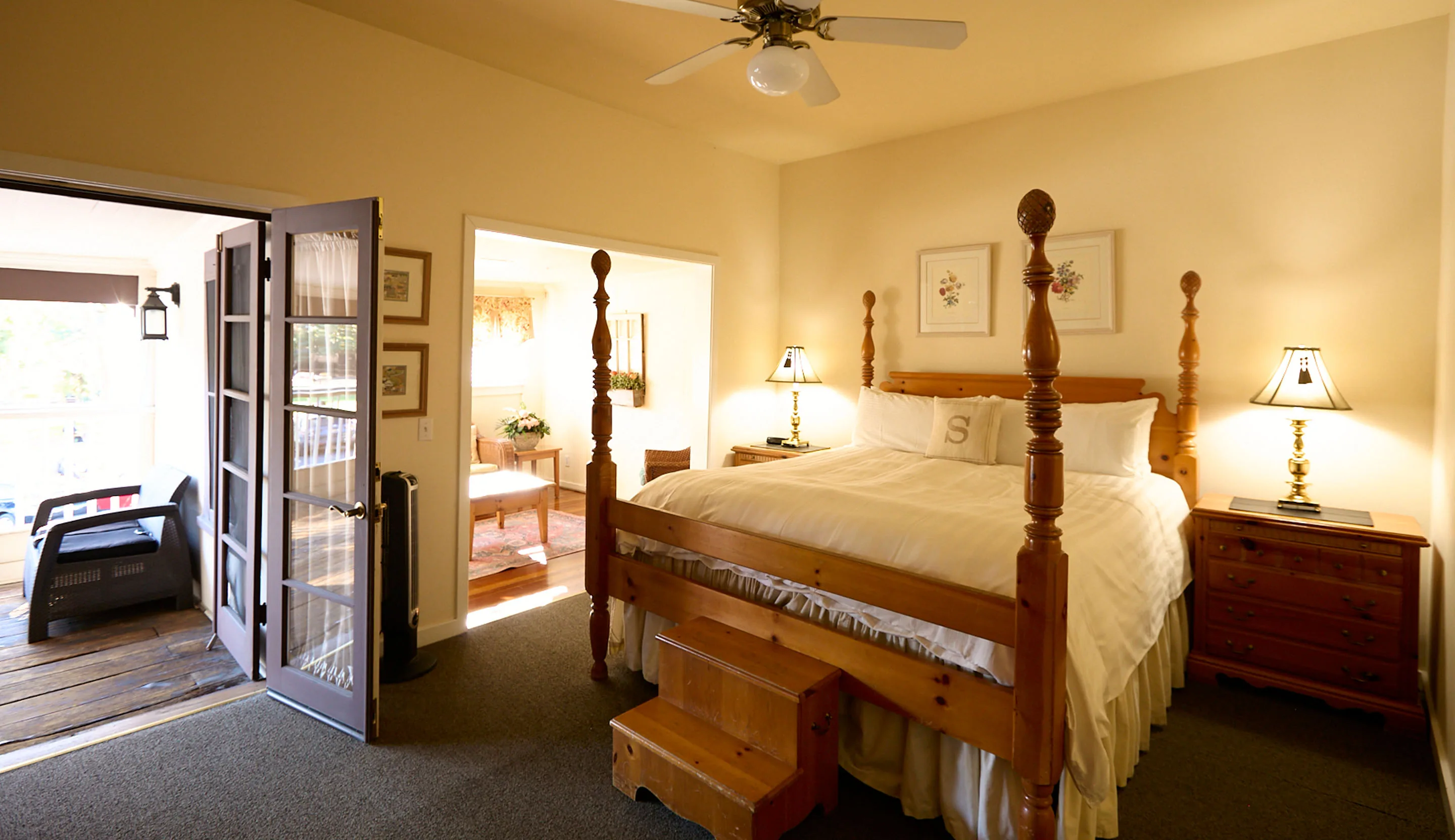 Room 4 at the Swiss Hotel, with a pine four-poster king bed and step stool and French doors opening to a sunny private patio